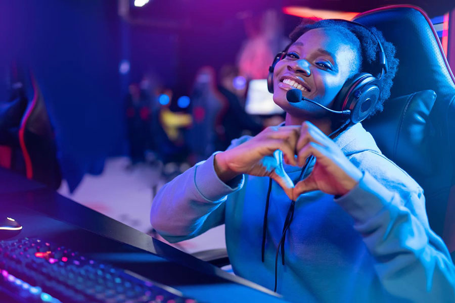 Image of a gamer making a heart with her hand.