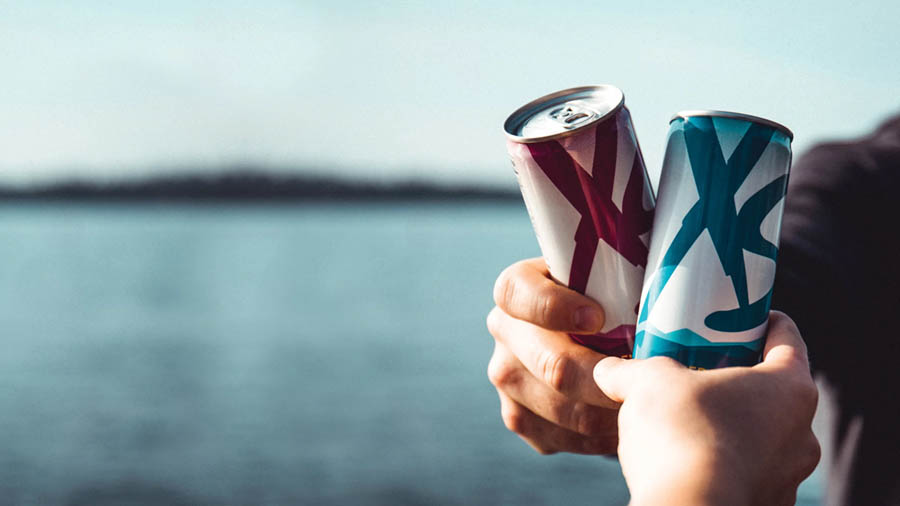 Image of two persons holding XS energy drinks close to one another.