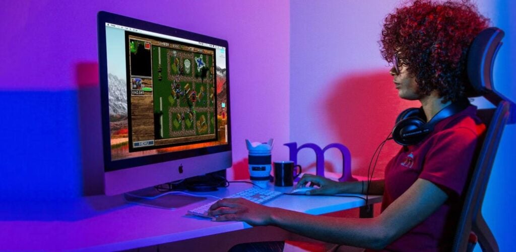 a picture of a woman playing games with her iMac
